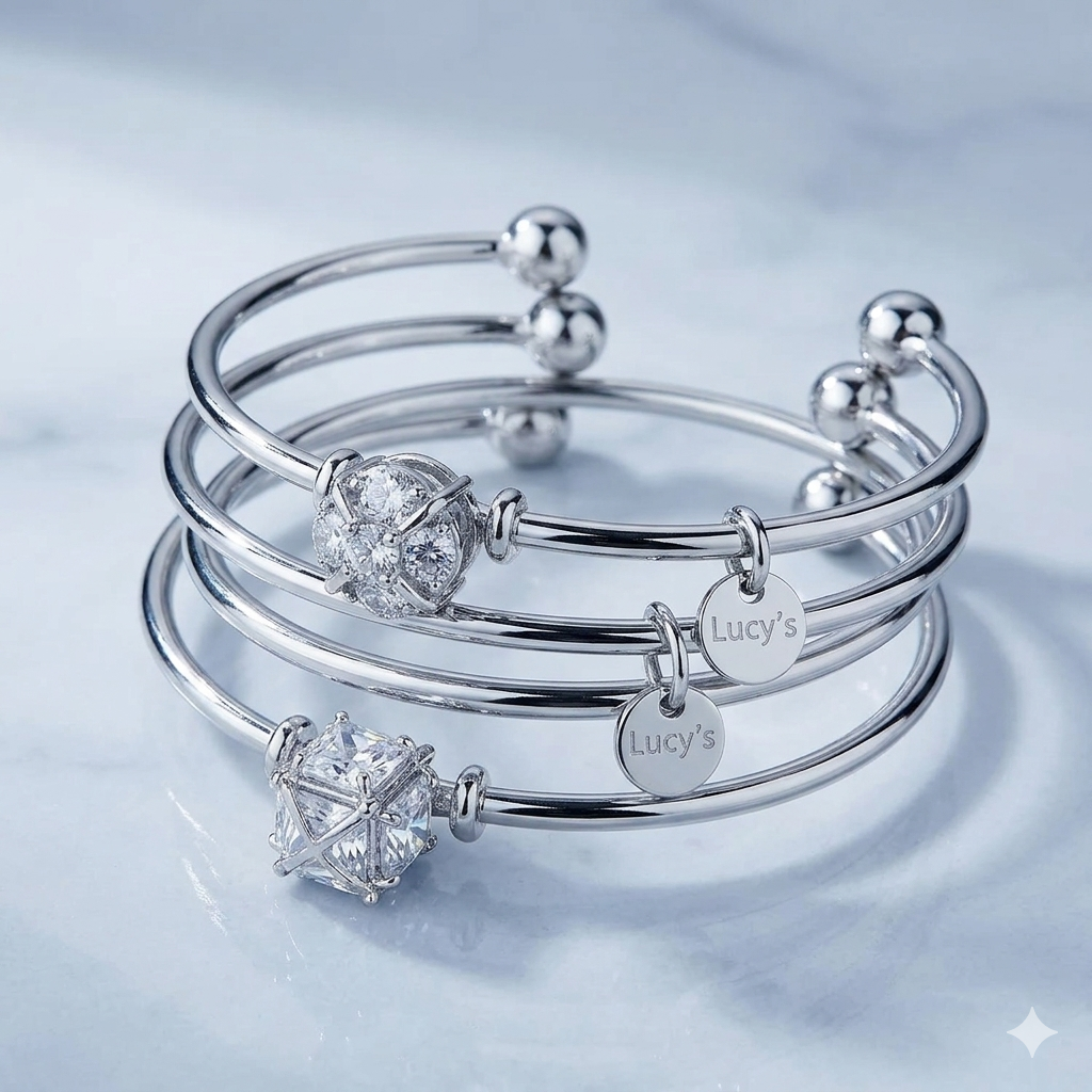 A close-up shot of three vintage silver bangles adorned with cubic zirconia and Lucy’s logo charms.